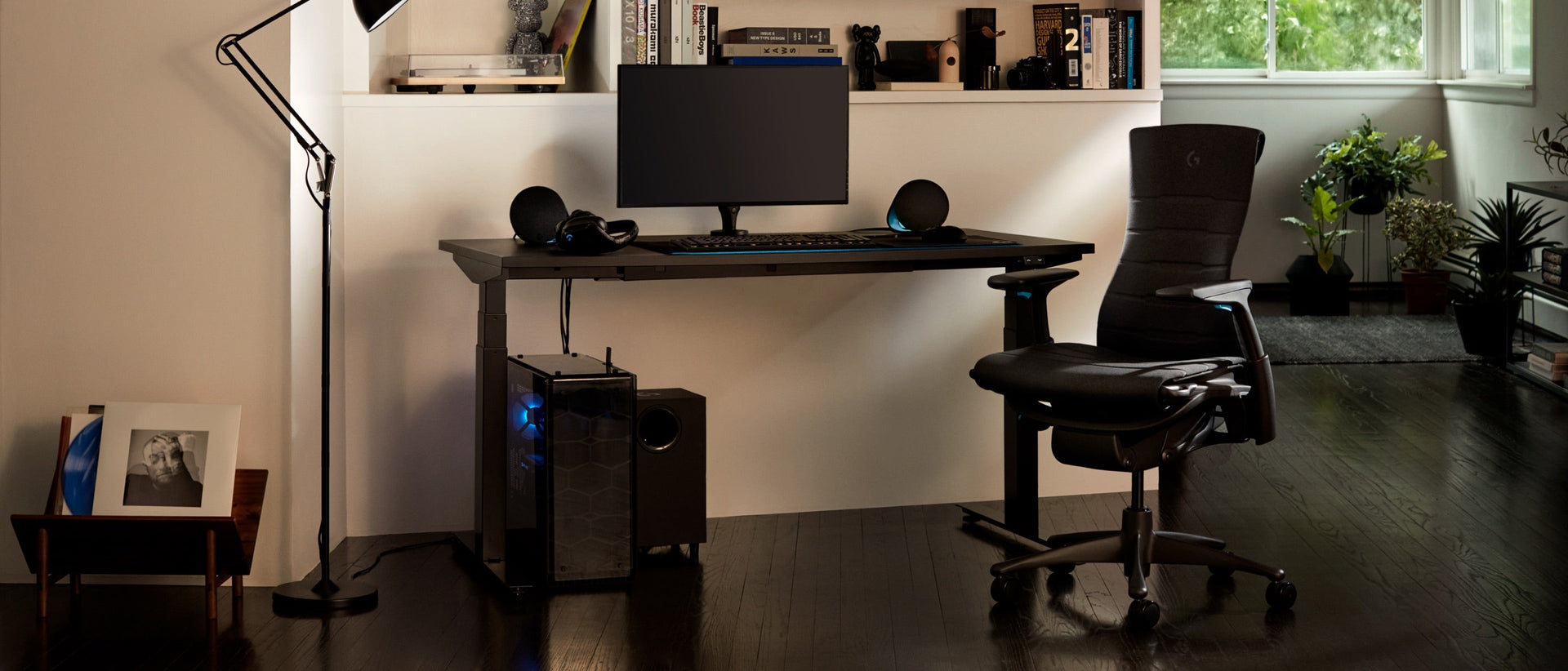A residential setting features the full set-up, including the Embody Gaming Chair, Ollin Monitor Arm and Motia Gaming Desk, at night